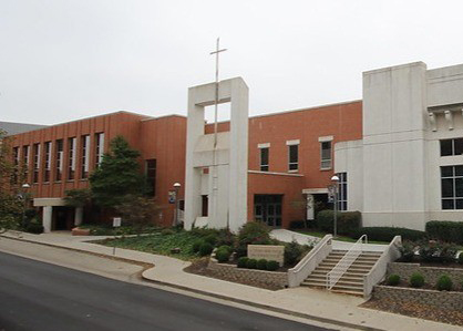 Modern brick and concrete church building with cross, stairs, greenery, and a touching array of testimonials under a cloudy sky.